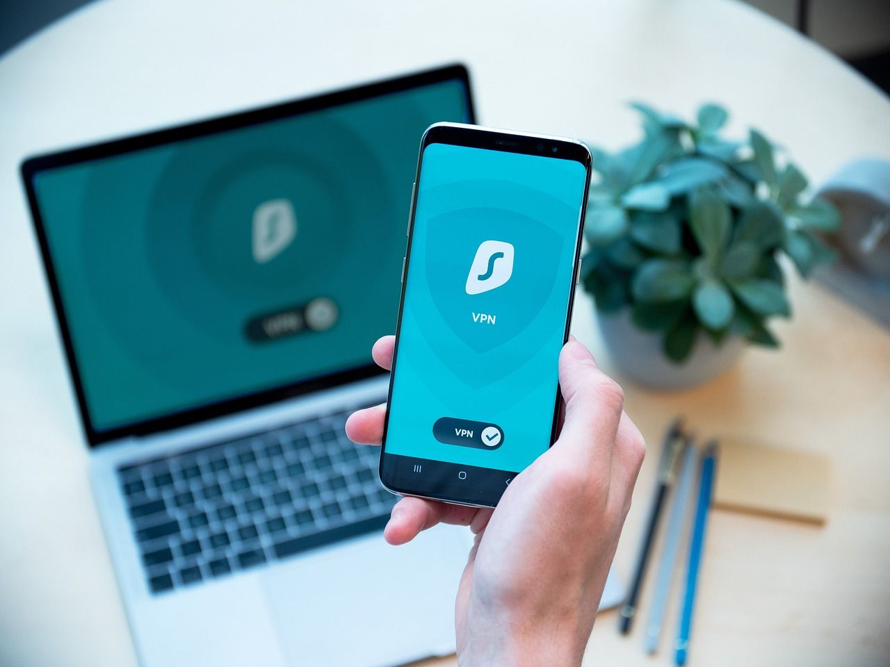 شخصی که گوشی هوشمند در دست دارد با Surfshark VPN فعال شده است 