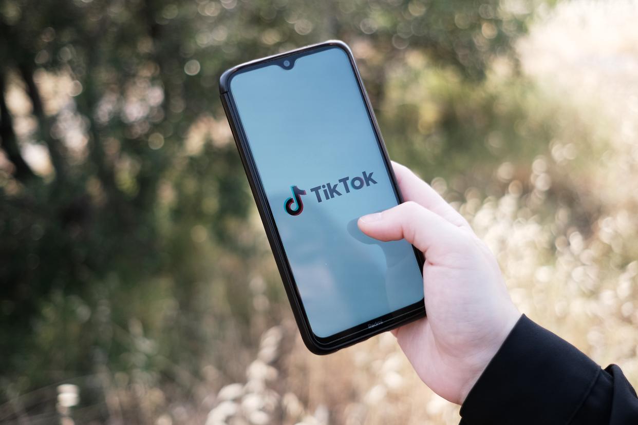 لوگوی TikTok که روی صفحه گوشی هوشمند نمایش داده می شود.