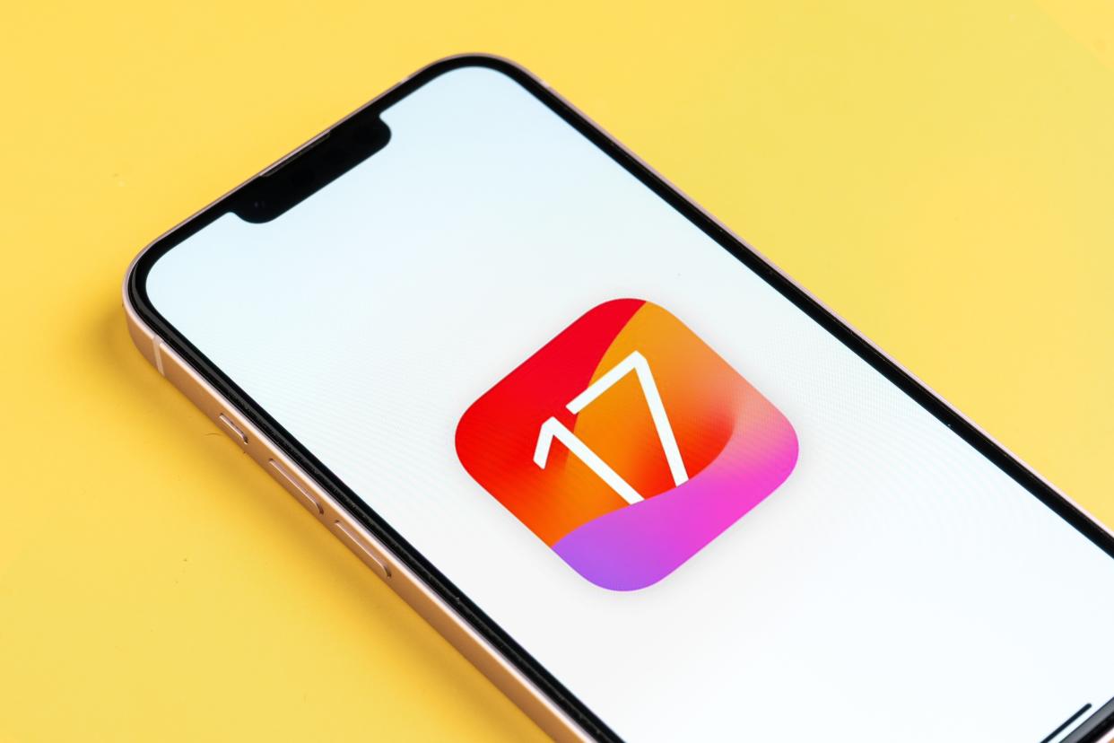 لوگوی iOS 17 در آیفون در برابر پس زمینه زرد