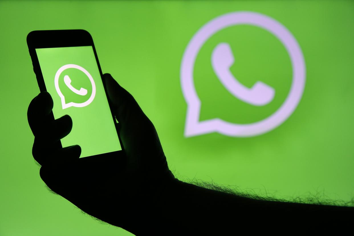 لوگوی WhatsApp و یک دست با گوشی هوشمند با استفاده از برنامه